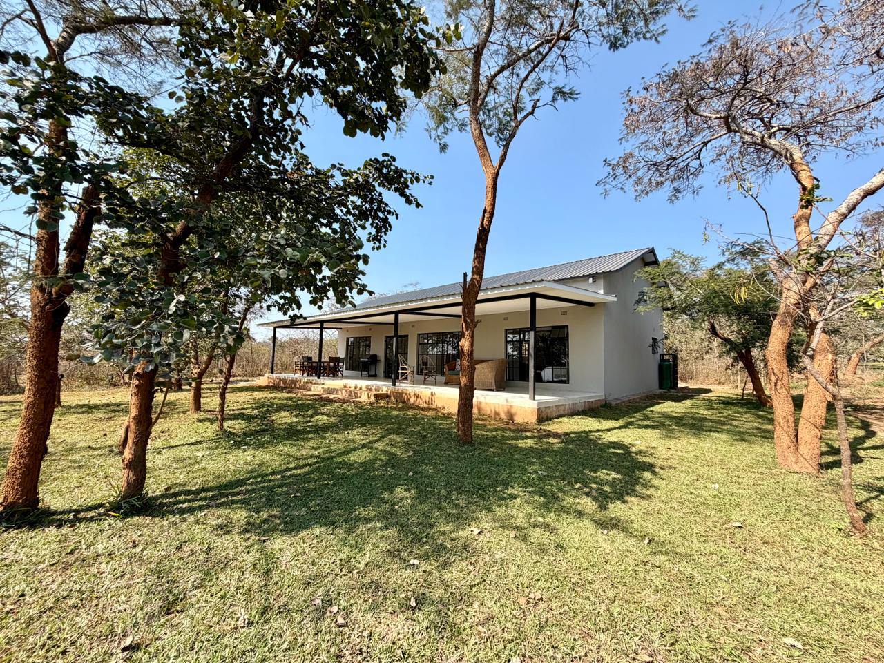 Marula Cottage in the trees, with a covered veranda looking onto the garden